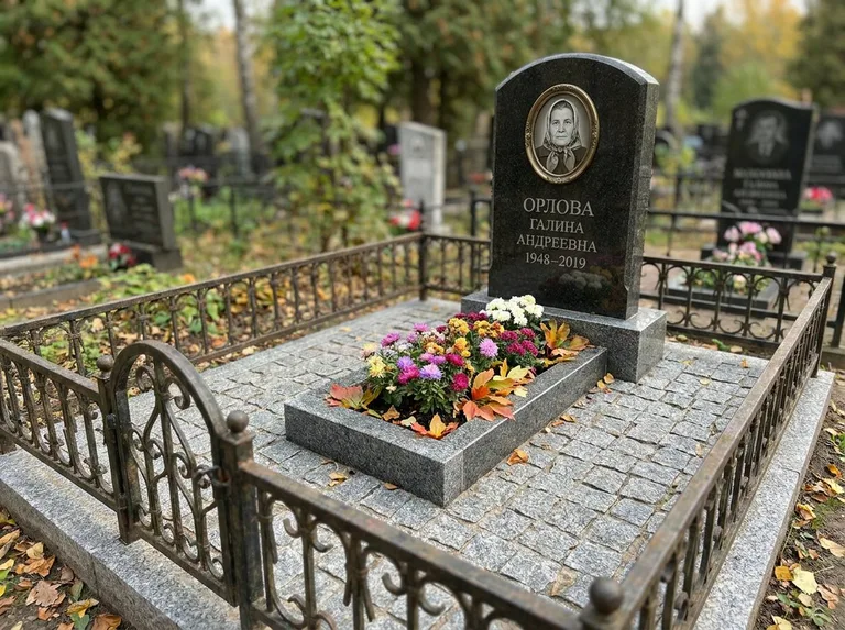 Благоустроенное захоронение с гранитной плиткой, оградой и цветником в Туле