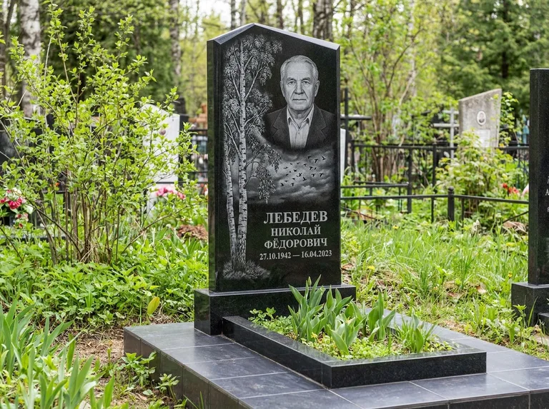 Памятник с гравировкой берёзы: вертикальная стела со скошенным верхом — берёза и стая птиц в небе, гранитный цоколь с тёмной плиткой, работа «Лебедев» в Туле