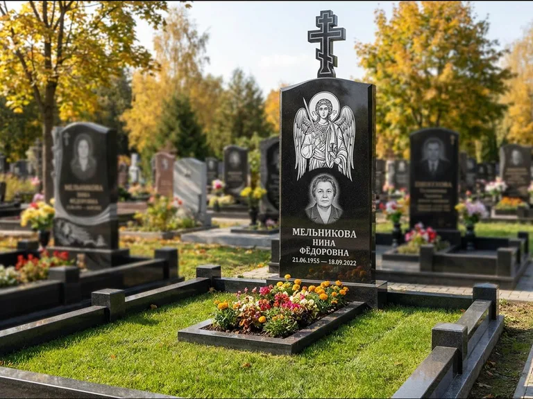 Памятник с гравировкой иконы: округлая стела-медальон с ликом — гравировка Богородицы «Семистрельная», луговые травы и полевые цветы за участком, работа «Гущин» в Туле