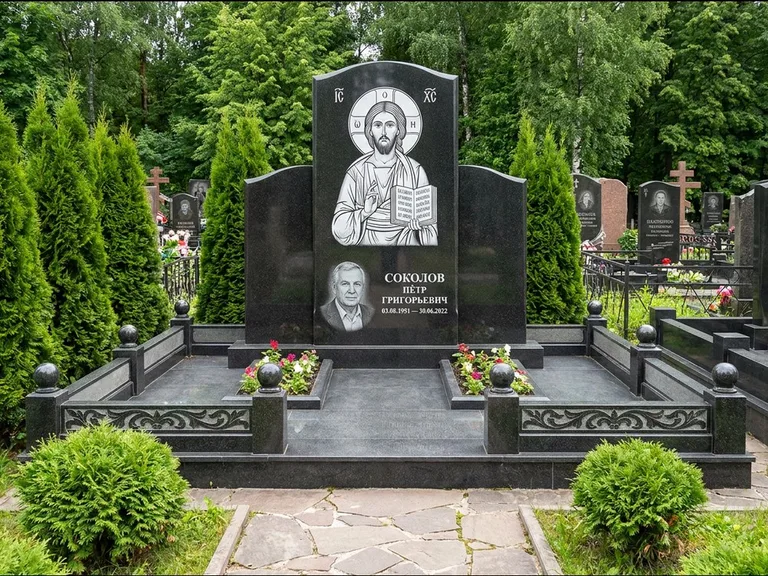 Памятник с гравировкой иконы: широкая горизонтальная лежачая плита-стела — икона в резной рамке-киоте, серая гравийная отсыпка с бордюром, работа «Богданова» в Туле