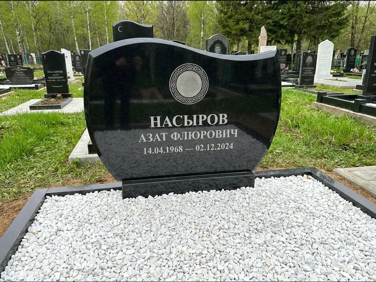 Мусульманский памятник: стела с волнообразным скошенным верхом — гравировка мечети под полумесяцем и звёздами, белая мраморная крошка с бордюром, работа «Насыров» в Туле