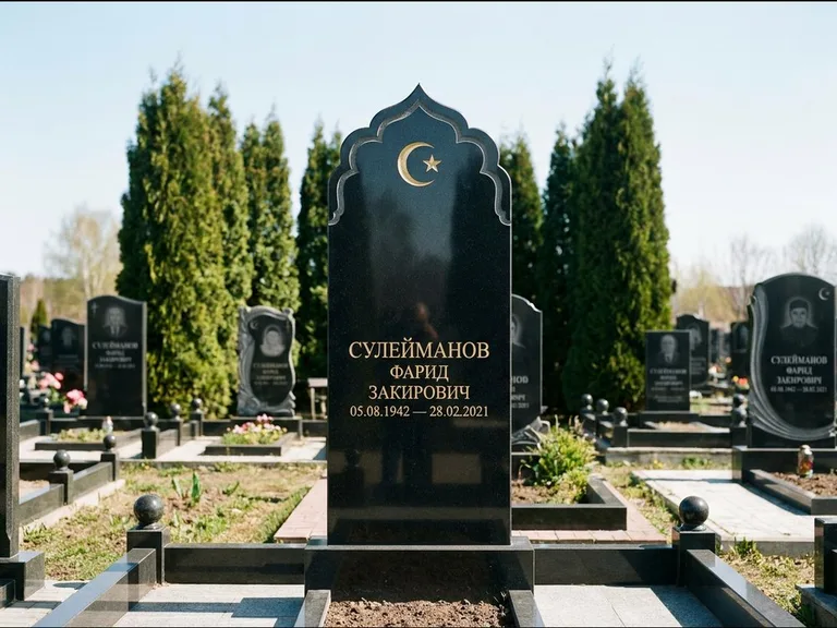 Мусульманский памятник: стела с резным восточным навершием-пиштаком — белая гравировка силуэта мечети с минаретами, высокие туи полукругом, работа «Сулейманов» в Туле