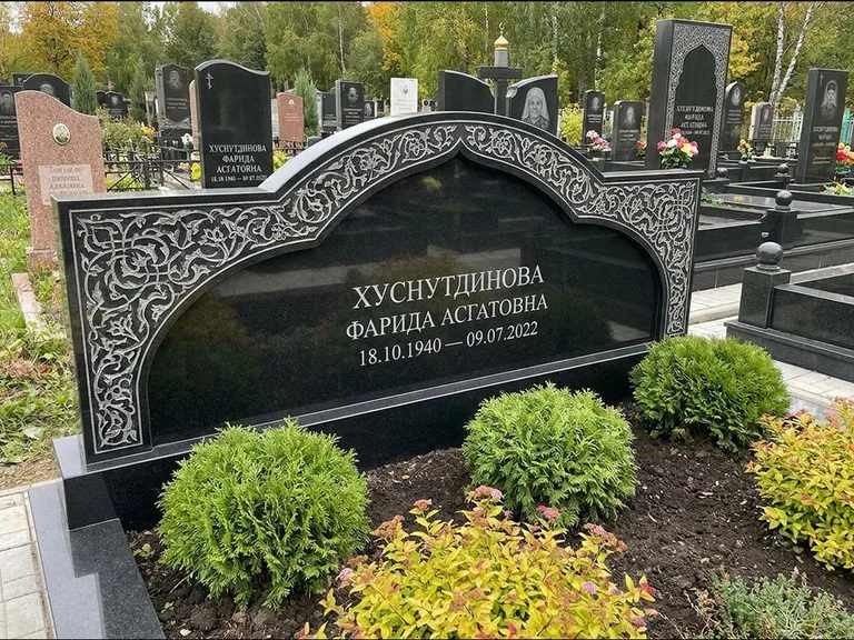 Мусульманский памятник: вытянутая горизонтальная семейная стела с аркой — белая гравировка силуэта мечети с минаретами, участок с декоративными кустами, работа «Зарипова» в Туле