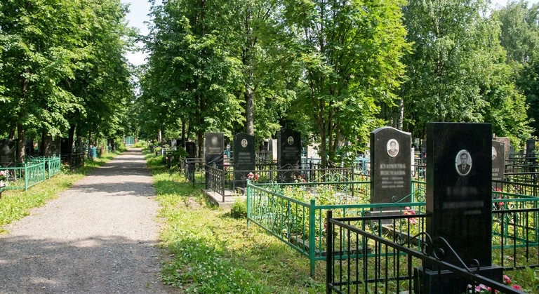 Гранитный памятник на семейном участке среди соснового леса Шарташского кладбища в Екатеринбурге
